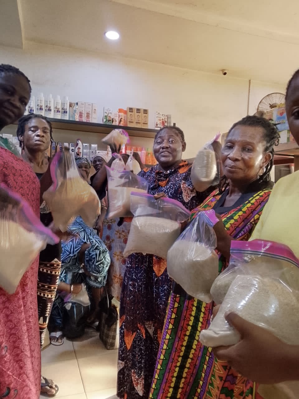 Women holding bags of rice at a food distribution event