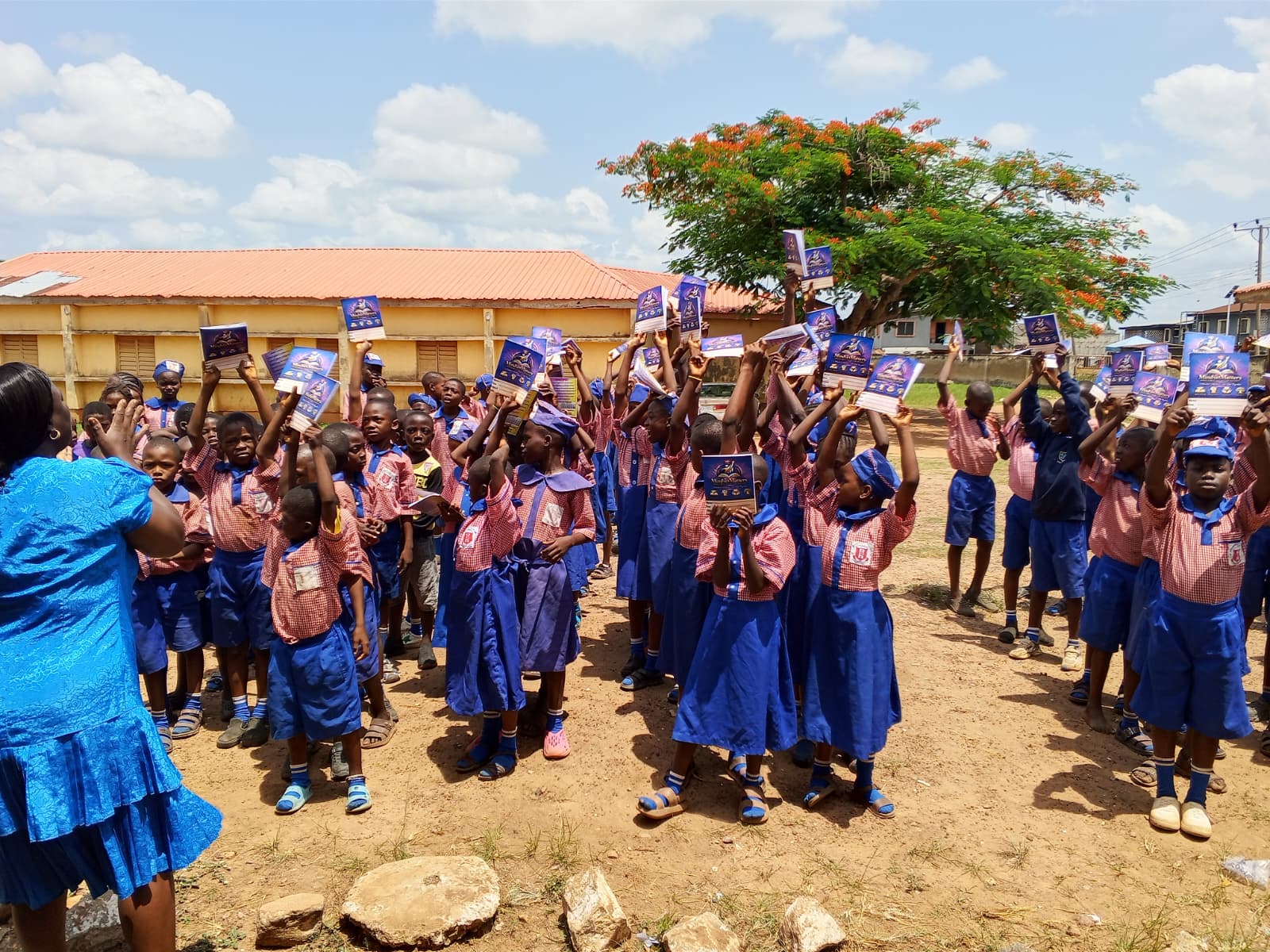 Schoolchildren holding up donated notebooks